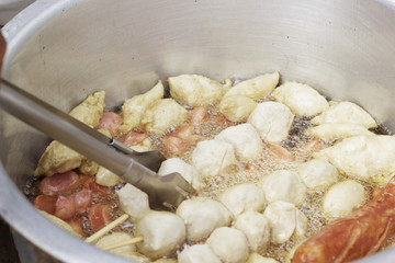 Meatballs frying in a pot