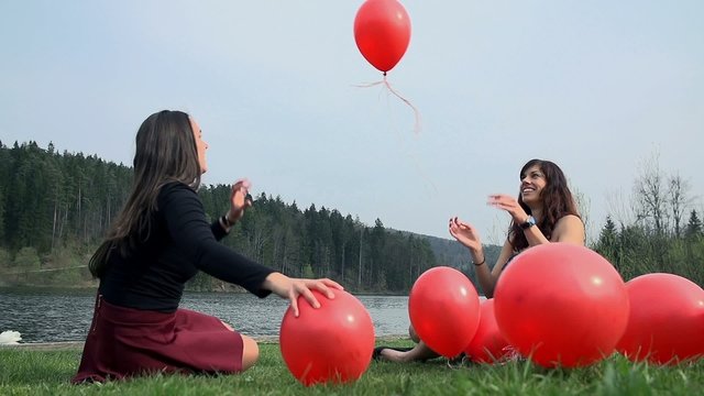 Playing With Red Balloons At Lake in Slow Motion