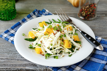 Fresh cabbage salad and orange on a plate