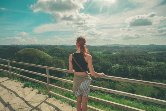 Young woman admiring jungle landscape from top of hill