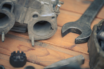 Carburetors for a car engine with tools on wooden table