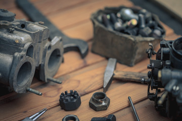Carburetors for a car engine with tools on wooden table