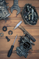 Carburetors for a car engine with tools on wooden table