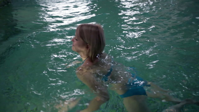 Still shot of a pretty young woman in blue bikini that swimms past the camera