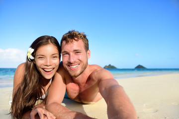Fototapeta premium Couple relaxing on beach taking selfie picture