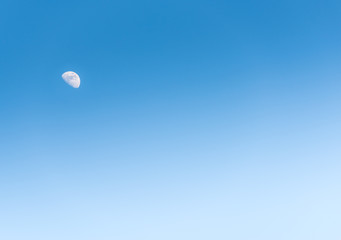 the moon in the day on blue sky