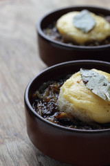 French onion soup with toast and melted cheddar on top.