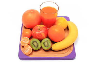 Fresh natural fruits and glass of juice on cutting board