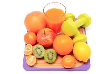 Fresh fruits, dumbbells and glass of juice