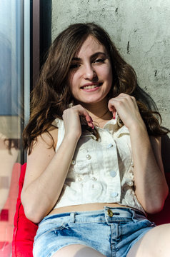 Cheerful young teen girl in denim shorts