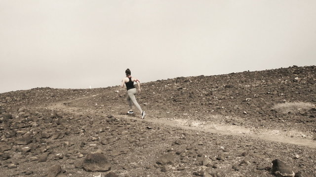 Woman jogging on desert, slow motion shot at 240fps 