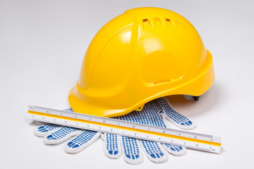 builder's tools - helmet, work gloves and ruler over white