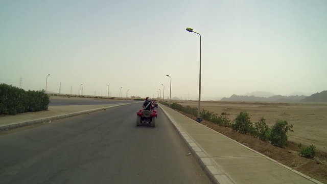 People driving on quadro motorcycles in Egypt
