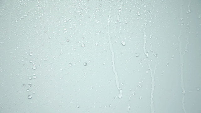 Close up of water drops running on glass