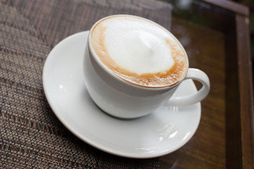 Cup of cappuccino over wooden table