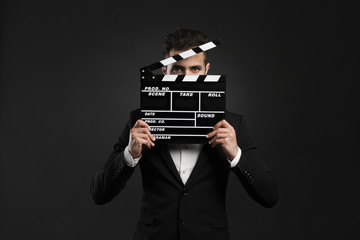 Business man holding a clapboard - 77450010