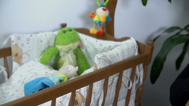 Close shot of prepared crib and soon to be mother who eats some fruits