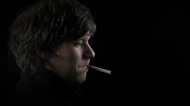 Male lighting a cigarette with a lighter shot in slow motion