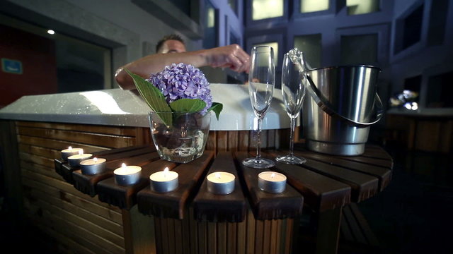 man prepare glasses and champagne to celebrate with his girlfriend