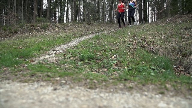 Two Female Friends Running Out Of Forest Down The Track
