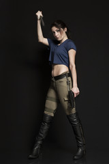 Frau mit Waffen vor dunklem Hintergrund