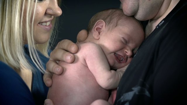 Baby smiles when father holdshim on his chest