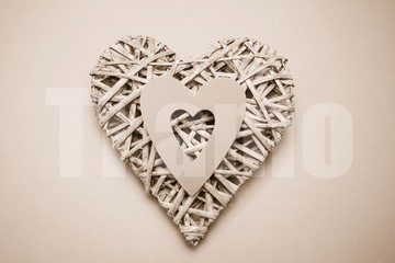 Composite image of wicker heart ornament with paper cut out