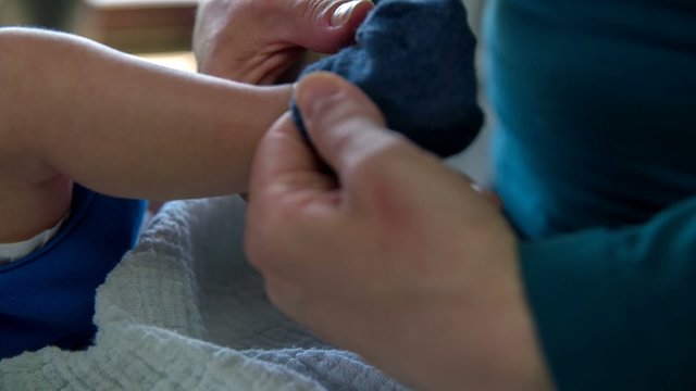 Mother putting socks on baby's feet