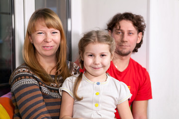 Happy family sitting on the windowsill in the room