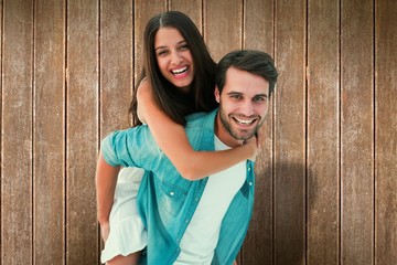 Happy hipster giving his girlfriend a piggy back