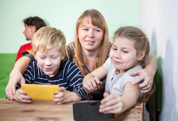 Mom taking away tablets pc in children, living room