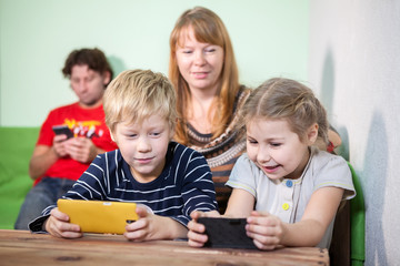 Mom look at children who play in pads, husband playing on phone