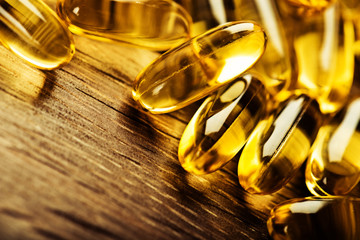 Fish oil omega 3 gel capsules  on wooden background - obrazy, fototapety, plakaty