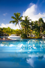 Fototapeta na wymiar art Deckchairs in tropical resort hotel pool