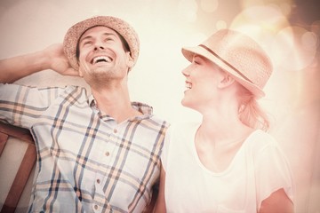 Young hip couple laughing on bench