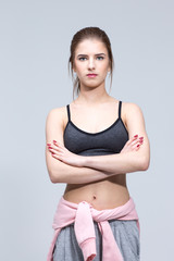 Portrait of a beautiful sporty woman over gray background