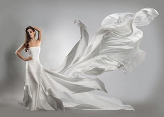 beautiful young girl in flying white dress. Flowing fabric