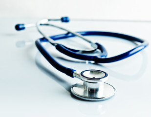 Stethoscope on blue, reflective background