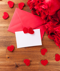 Envelope with roses on wooden table