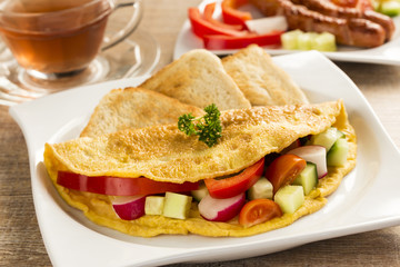 a nice omelet  with vegetables, on the table