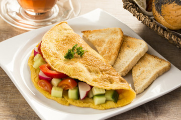 a nice omelet  with vegetables, on the table - obrazy, fototapety, plakaty