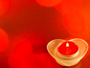 Red candle with fire on red background