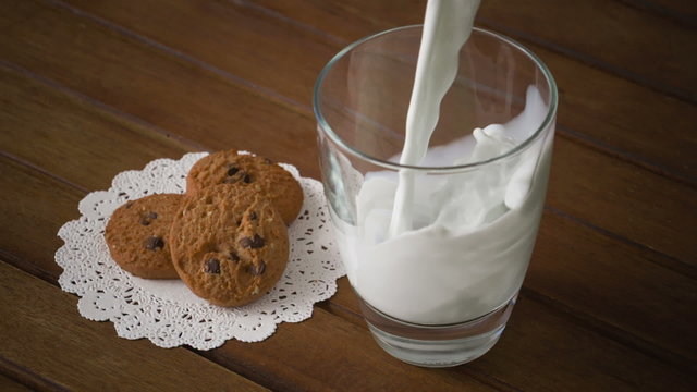 Cookies and glass of milk, on wooden table