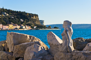 Mermaid sculpture carved out of rocks at Piran harbor, Istria