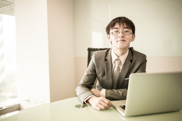 Fototapeta premium Young handsome man using laptop in his office