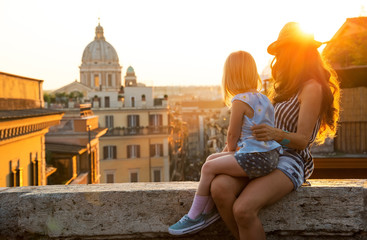 Fototapeta na wymiar Mother and baby girl sitting on street in Rome