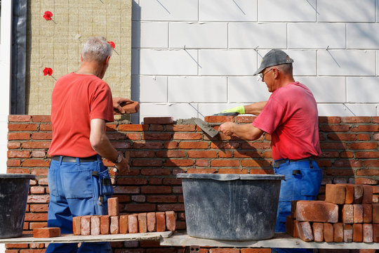 Bricklayers work together as a team