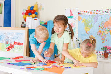 Fototapeta premium Three preschoolers in the classroom