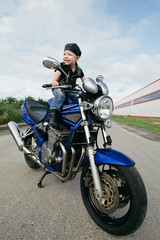 Fototapeta na wymiar little biker on road with motorcycle