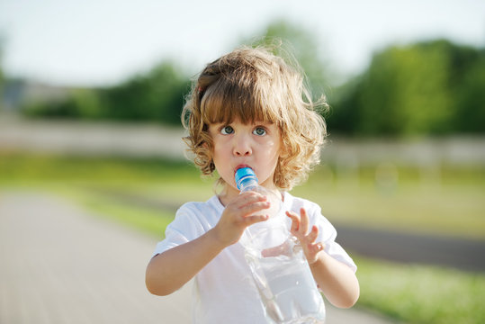 little girl drinking clean water from plastic bottle